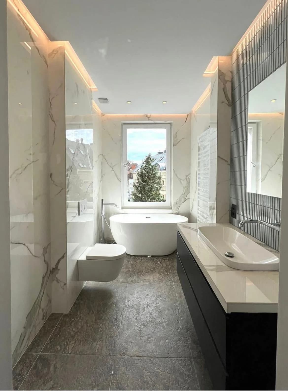 White marble bathroom with a freestanding bath and a wall hung unit